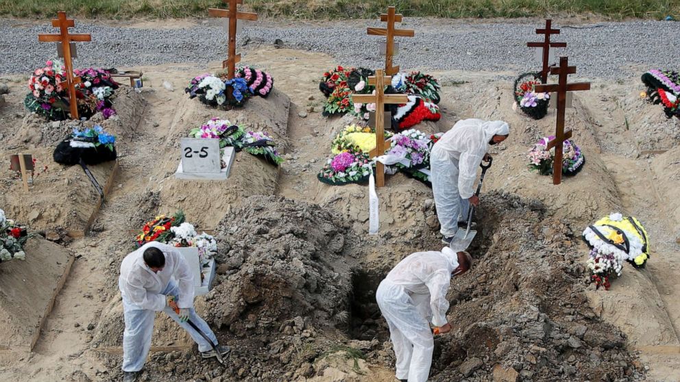 Phu đào huyệt đang mai táng một nạn nhân COVID-19 ở một nghĩa trang ngoại ô Saint Petersburg
