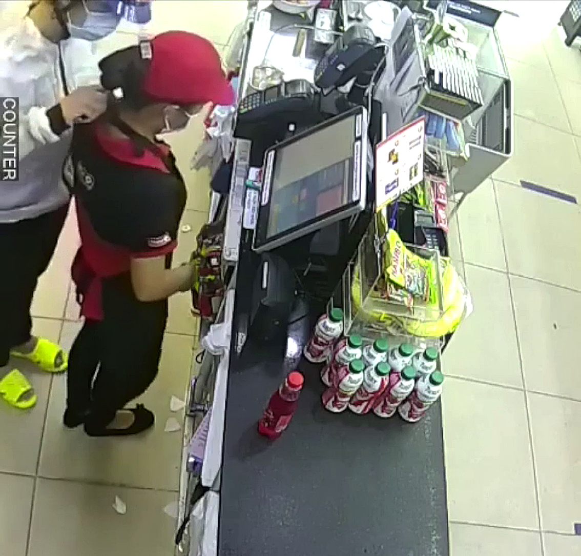 Tên trộm kề dao vào cổ nhân viên cửa hàng tiện lợi ở Q.8 để cướp tiền (ảnh từ camera cửa hàng)
