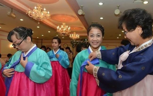 Các cô dâu ngoại quốc đang thực hành mặc trang phục Hanbok truyền thống của Hàn Quốc - Ảnh: Yonhap