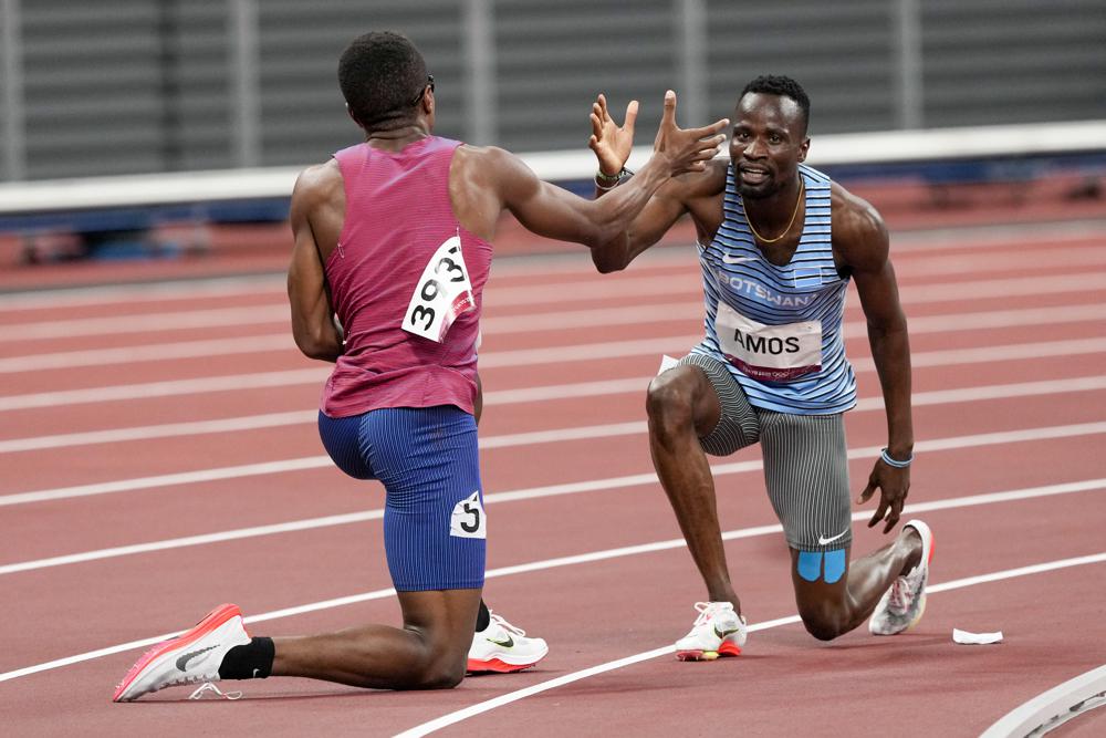 Isaiah Jewett (Mỹ) và Nijel Amos (Botswana) bắt tay nhau sau khi ngã ở trận bán kết 800m nam ngày 1/8. Ảnh: AP