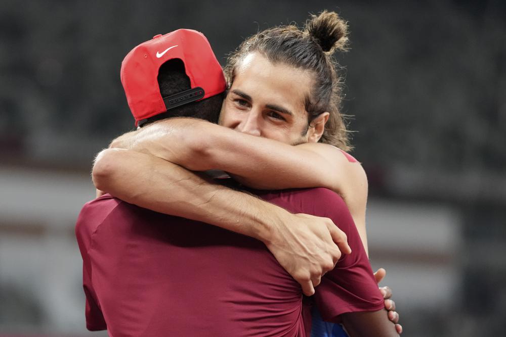 Gianmarco Tamberi (Ý) ôm lấy người cùng giành huy chương vàng Mutaz Barshim (Qatar) với mình sau trận chung kết nhảy cao nam tại Thế vận hội mùa hè 2020 ở Tokyo. Ảnh: AP