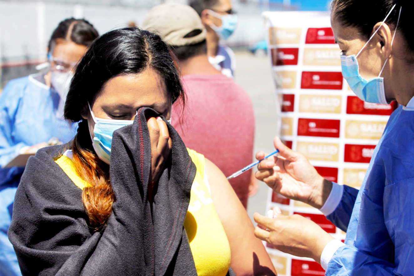 Một phụ nữ sống trong trại di cư El Chaparral gần biên giới Mỹ ở Tijuana, Mexico được tiêm liều vắc-xin Pfizer đầu tiên - ẢNH: REUTERS