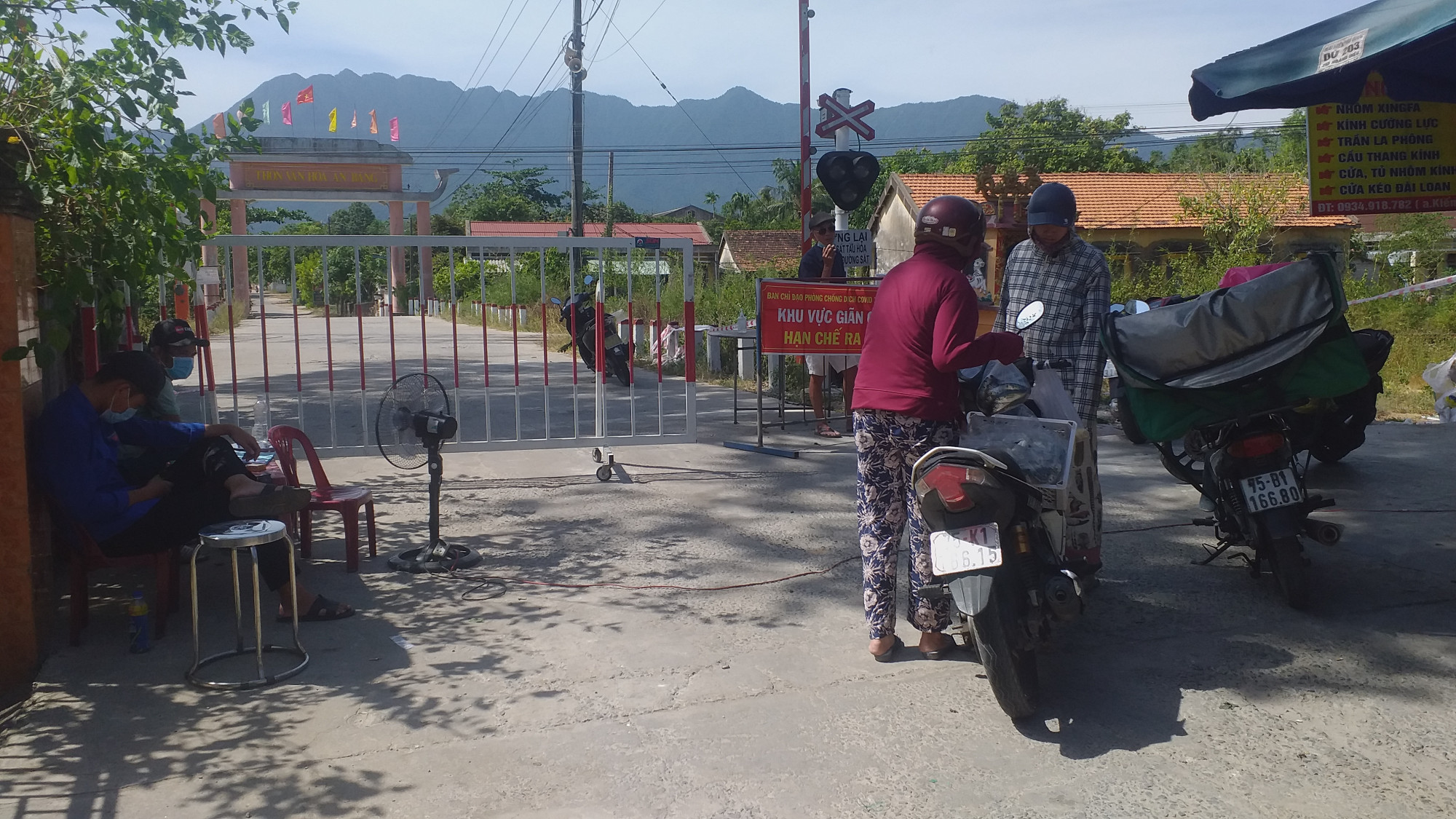 Người dân cung cấp lương thực, thực phẩm (mặt hàng thiết yếu) qua rào chắn cứng tại thôn An Bàng, xã Lộc Thủy sáng ngày 7/8, dù biện pháp phong tỏa đã được thay đổi từ 28/7