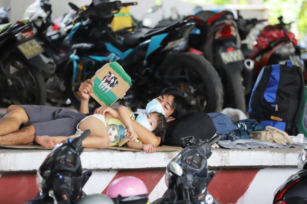 Người dân đi xe máy từ TP.HCM về đến chốt kiểm soát y tế tại thị trấn Lăng Cô (H.Phú Lộc, tỉnh Thừa Thiên - Huế) chờ làm thủ tục để đi cách ly tập trung