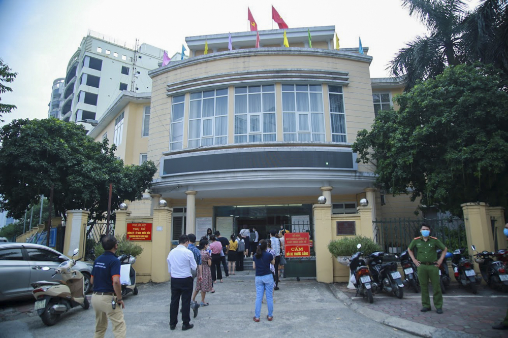 Cùng thời điểm, tại trụ sở UBND phường Dịch Vọng Hậu (86, Trần Thái Tông, quận Cầu Giấy), hai hàng dài người dân xếp hàng chờ xin xác nhận.