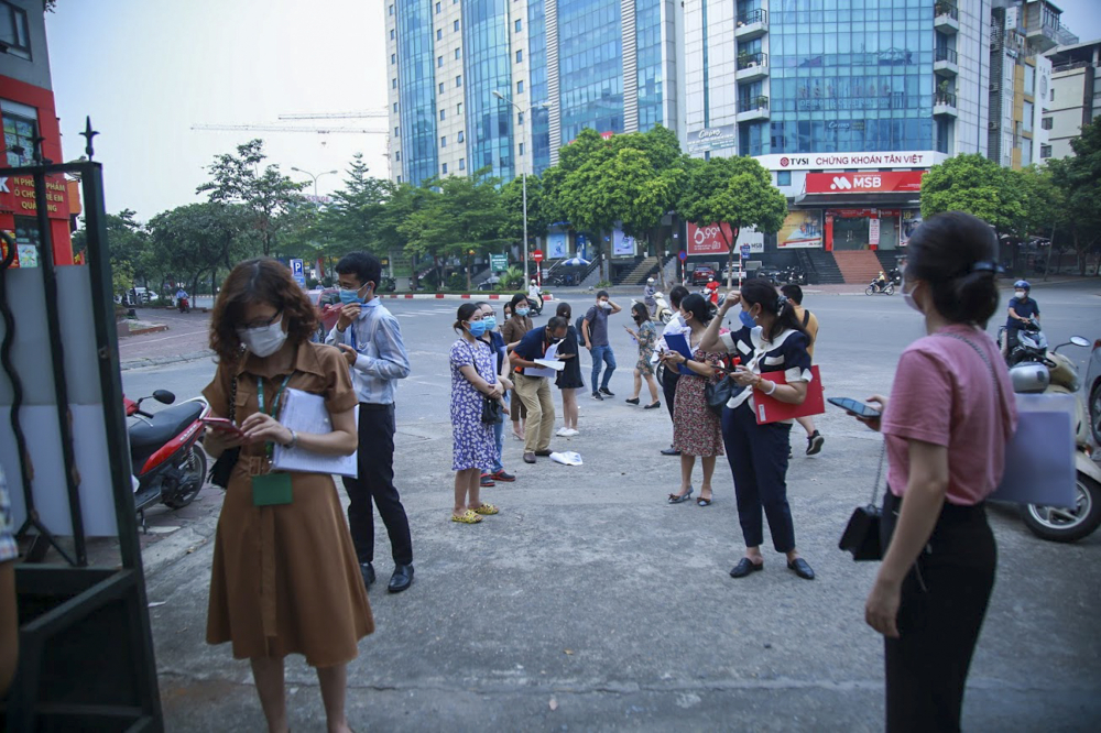 Số lượng người dân đến khá đông ước tính mỗi hàng khoảng 20 người, mọi người đứng tràn ra phía ngoài đường Trần Thái Tông. Cán bộ tại trụ sở phường thường xuyên đi lại nhắc nhở 'đảm bảo giãn cách'.