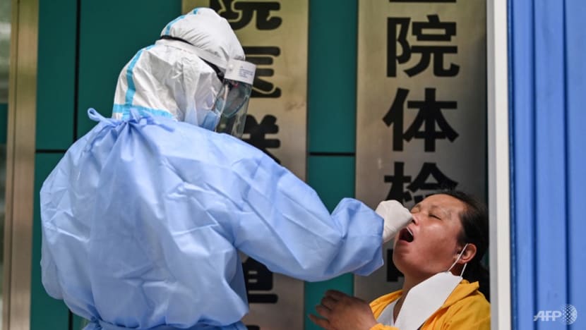 Một nhân viên y tế lấy mẫu tăm bông từ một phụ nữ để xét nghiệm COVID-19 ở Vũ Hán, Trung Quốc vào ngày 13 tháng 5 năm 2020.