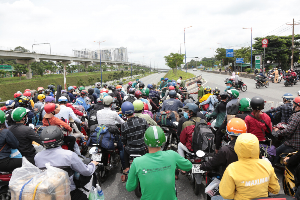 Từ sáng sớm, xa lộ Hà Nội qua khu vực công viên Suối Tiên và bến xe Miền Đông mới có rất nhiều xe máy lưu thông, đa số là người lao động ở TPHCM chạy xe về quê