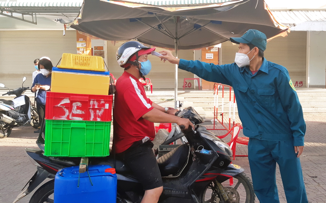 Đo thân nhiệt cho người vào chợ truyền thống ở tỉnh Phú Yên