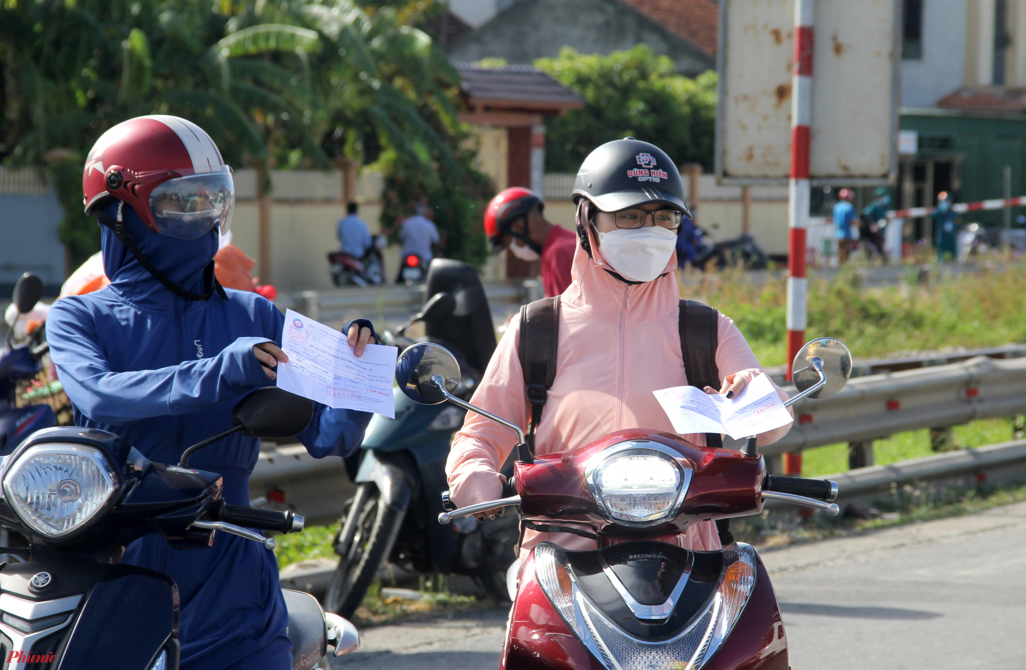 Người dân trưng giấy test nhanh COVID-19 để ra vào TP. Vinh