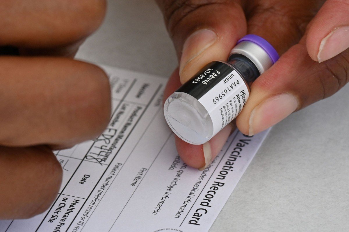 Một nhân viên y tế điền vào thẻ tiêm chủng COVID-19 ở Los Angeles vào ngày 11 /8 - Ảnh: AFP