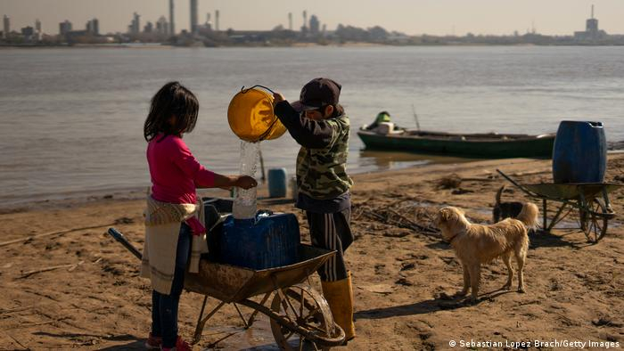 Trẻ em lấy nước từ một con sông ở Rosario, Argentina - Ảnh: DW/Getty Images