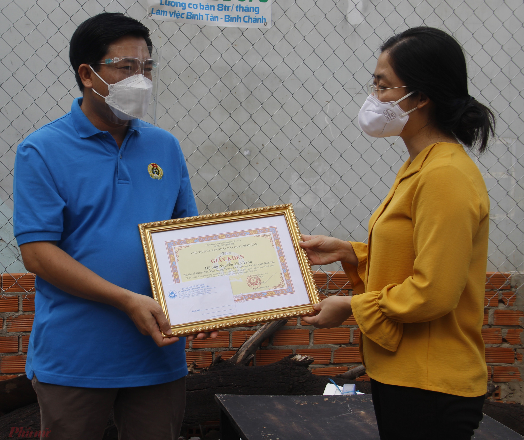 Bà Lê Thị Ngọc Dung tặng giấy khen của quận Bình Tân cho ông Nguyễn Văn Trọn.