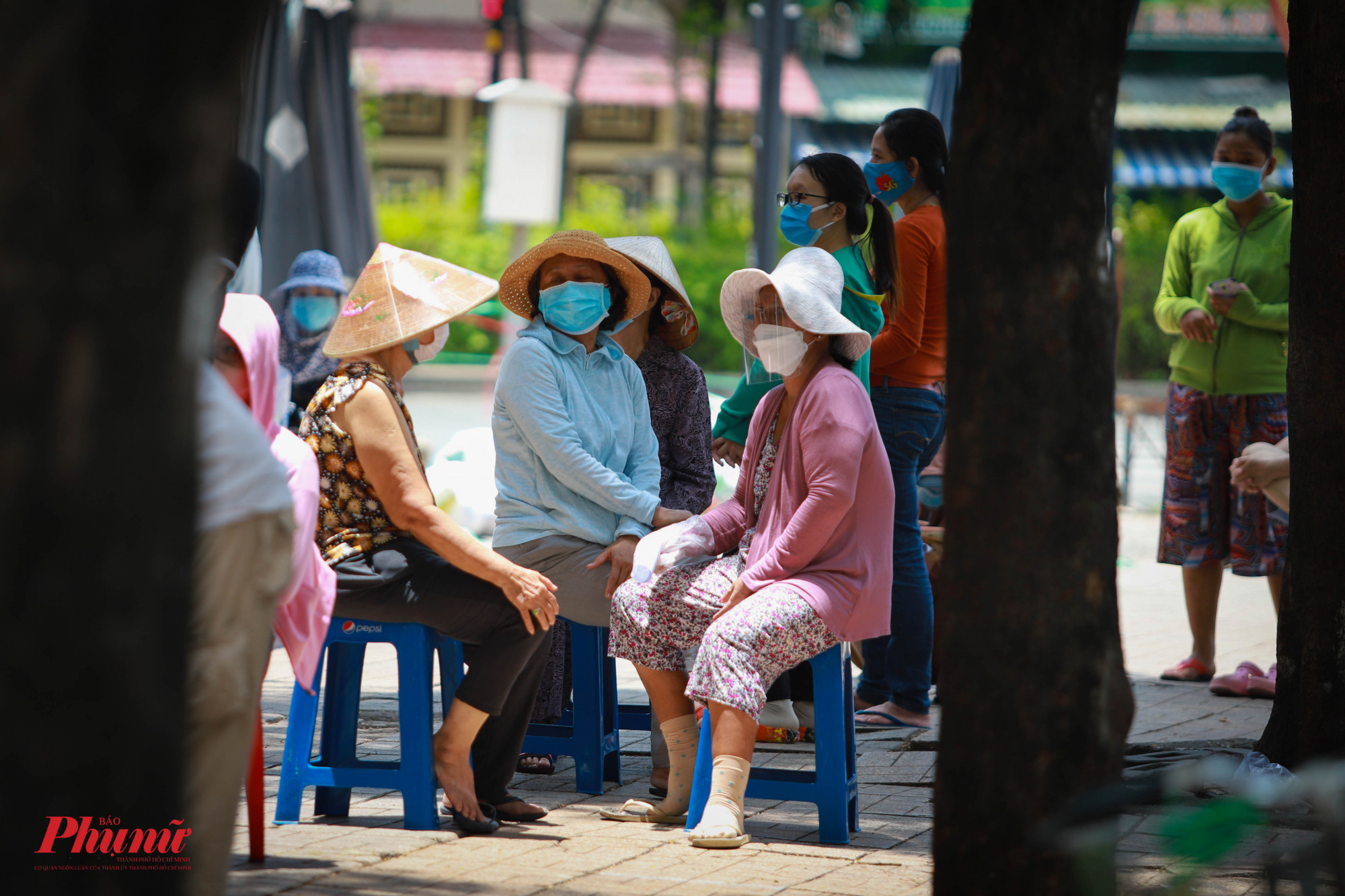 Một số người hàng xóm tranh thủ buôn chuyện lúc chờ đợi