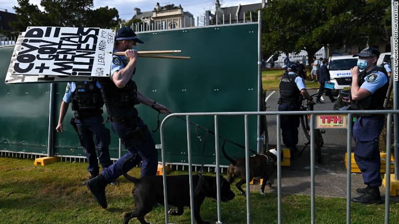 Cảnh sát tịch thu biểu ngữ của những người biểu tình chống phong tỏa ở Sydney ngày 21/8 - Ảnh: CNN