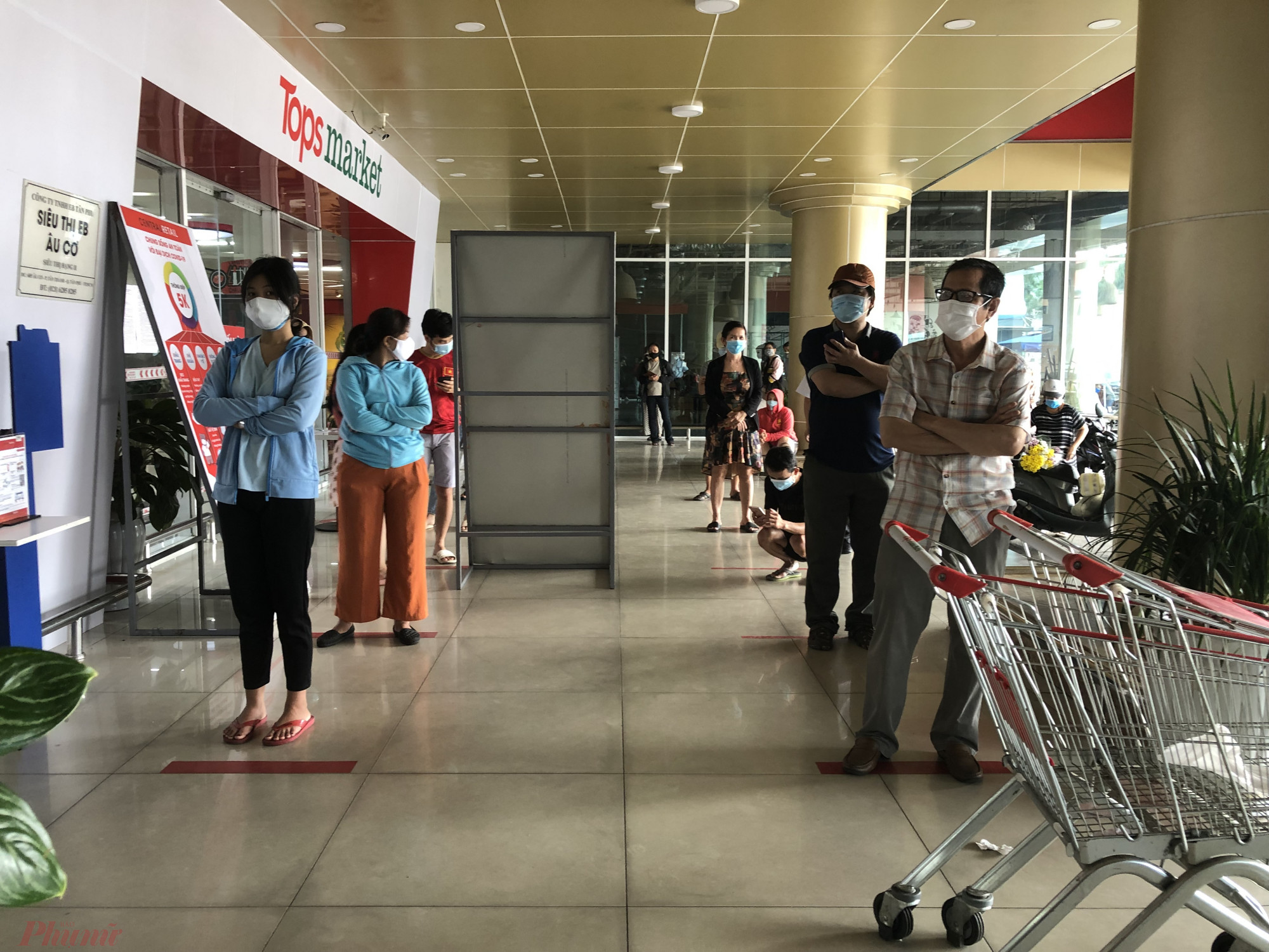 Tại siêu thị Topsmarket đường Âu Cơ (Q.Tân Phú), khách cũng xếp hàng rất đông, mỗi lượt chỉ được vào 2 người, khuôn viên cả siêu thị là 20 khách hàng.