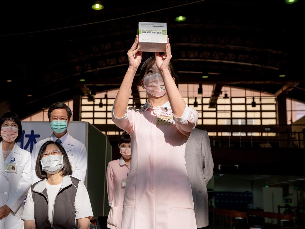Một điều dưỡng cầm lọ vắc xin sản xuất trong nước Medigen đầu tiên với phía trái là Tổng thống Đài Loan đang trong tư thế sẵn sàng được tiêm tại Bệnh viện Đại học Đài Loan (Đài Bắc). Ảnh: AP