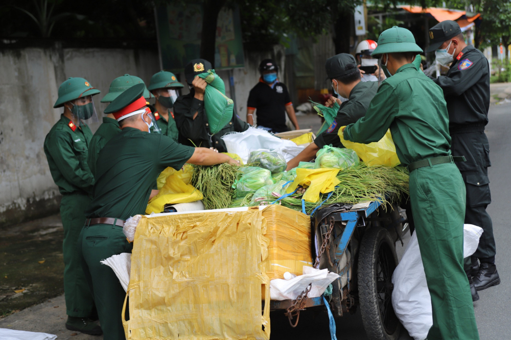 Các lực lượng công an, bộ đội dùng xe ba gác vận chuyển đồ ăn đến phát cho người dân khó khăn 