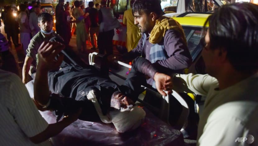 Nhân viên y tế và bệnh viện đưa một người đàn ông bị thương lên cáng để điều trị sau hai vụ nổ bên ngoài sân bay ở Kabul