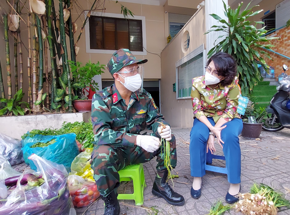 Chủ tịch Ủy ban MTTQ Việt Nam TPHCM Tô Thị Bích Châu hỏi thăm chiến sĩ tăng cường cho Trung tâm An sinh quận 4 hỗ trợ nhu yếu phẩm cho người dân.