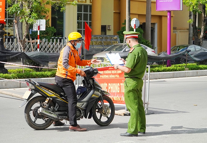 Lực lượng cảnh sát khu vực phường Đồng Phú TP. Đồng Hới kiểm tra giấy đi đường của người dân khi qua chốt. Ảnh: N.H