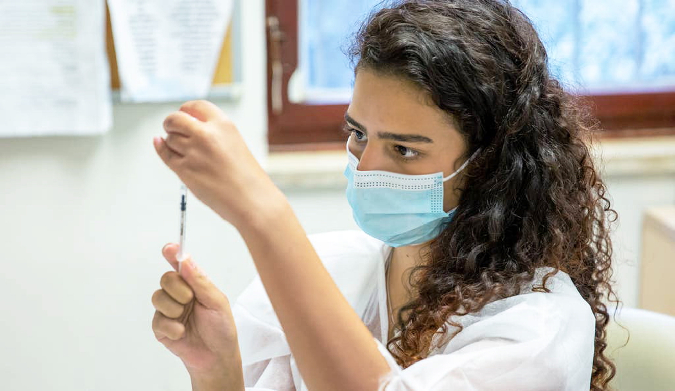 Một nhân viên y tế chuẩn bị tiêm mũi vắc-xin Pfizer liều thứ ba ở Jerusalem, Israel - Ảnh: Emil Salman/Haaretz