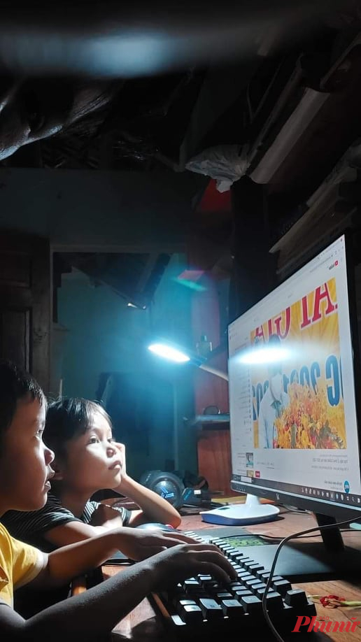 em Hồ Hải Triều cùng bạn được cha mẹ mở laptop, cho theo dõi Lễ khai giảng trên trang Youtube - ảnh Thanh Vạn