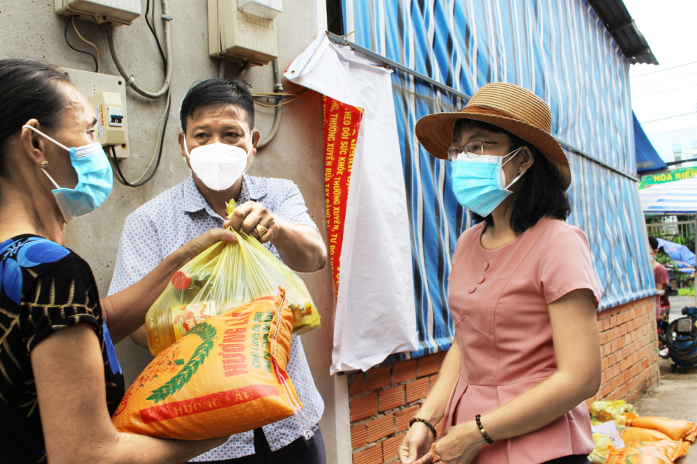 Ông Nguyễn Hữu Linh - Trưởng ban Điều hành khu phố 3, thị trấn Tân Túc, H.Bình Chánh, TP.HCM - phát quà cho những người thuê trọ  có hoàn cảnh khó khăn trong khu phố