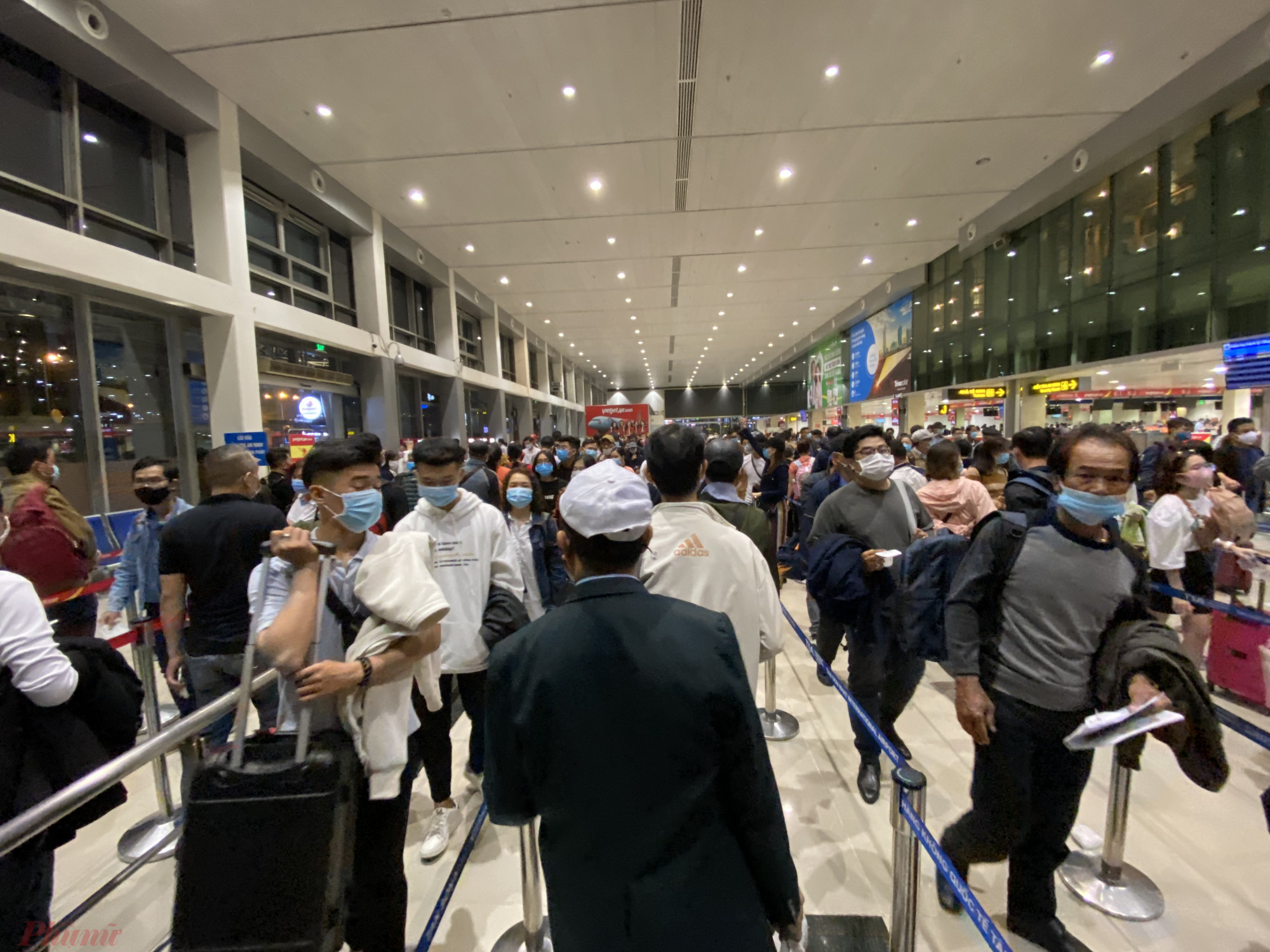 Khách bay xếp hàng dài đề chờ vào khu vực soi chiếu an ninh tại sân bay Tân Sơn Nhất - Ảnh: Quốc Thái
