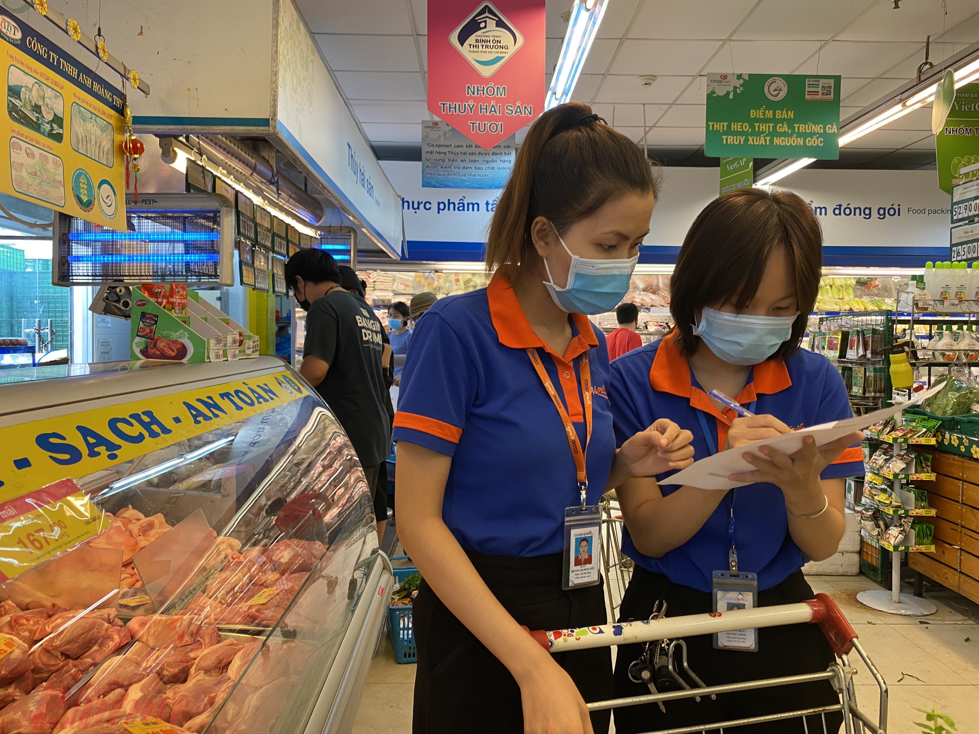 Lực lượng công tác viên, nhân viên siêu thị đi chợ hộ người dân tại TPHCM - Ảnh: Quốc Thái