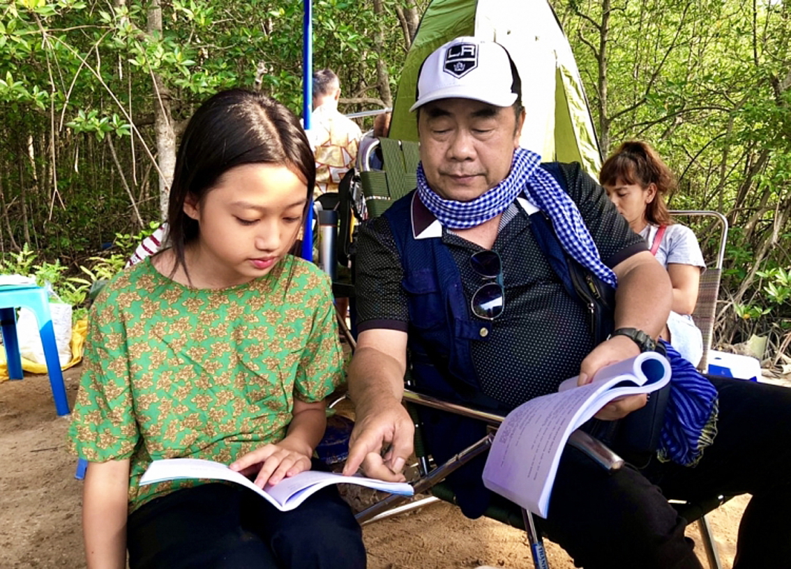 Đạo diễn Trần Ngọc Phong và diễn viên nhí Cát Vi trên phim trường Cơn giông