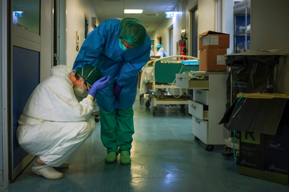 Một y tá an ủi đồng nghiệp khi họ thay ca tại bệnh viện Cremona, phía đông nam Milan vào ngày 13/3/2020, trong thời gian phong tỏa ở Ý. (Ảnh: AFP)