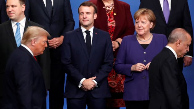 Tổng thống Pháp Emmanuel Macron (2 L) và Thủ tướng Đức Angela Merkel (R) nhìn Tổng thống Mỹ Donald Trump (trước L) và Tổng thống Thổ Nhĩ Kỳ Recep Tayyip Erdogan (trước R) đi ngang qua họ trong một bức ảnh gia đình trong khuôn khổ hội nghị thượng đỉnh NATO tại khách sạn Grove ở Watford, phía đông bắc London vào ngày 4 tháng 12 năm 2019