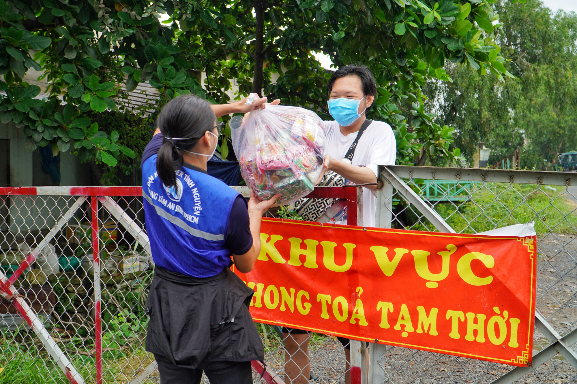 Tình nguyện viên đội SOS giao túi an sinh trực tiếp cho người dân khó khăn