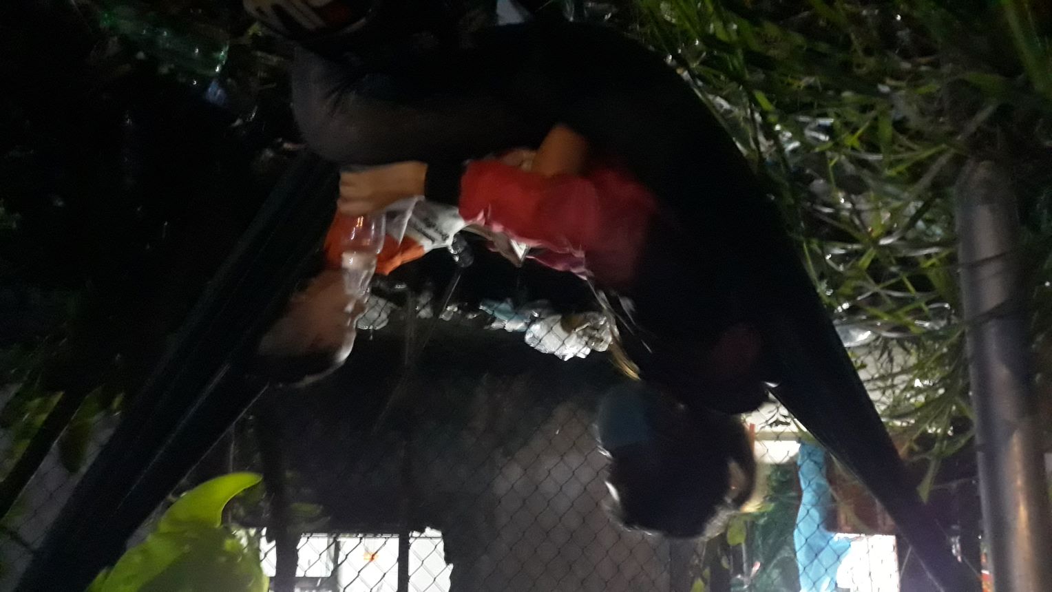 Một đứa trẻ khác được mẹ ru ngủ trên chiếc võng giăng tạm cạnh quốc lộ 1
