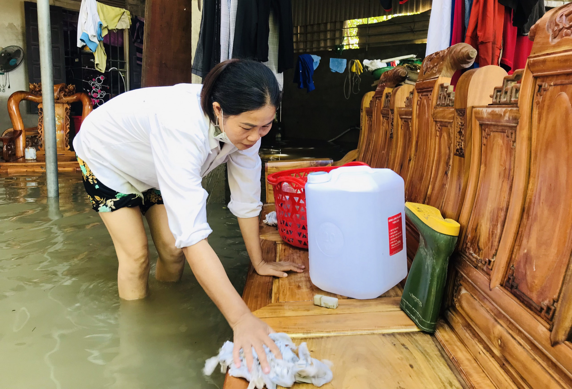 Lũ bắt đầu rút ra khỏi nhà, nhiều người dân xã Quỳnh Hồng (huyện Quỳnh Lưu) tranh thủ tận dụng dòng nước lũ để vệ sinh, lau chùi bùn đất bám trên đồ dùng.