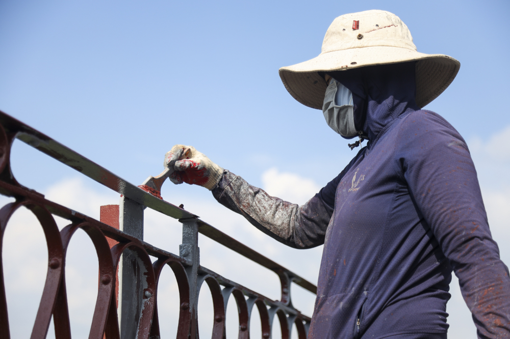 Thành cầu Long Biên chiều từ Hà Nội sanng đang được công nhân vệ sinh, sơn lót chống gỉ.