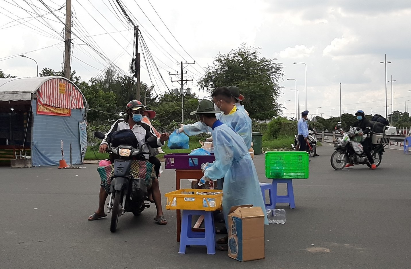 Lực lượng chức năng tại Vĩnh Long phát cơm và nước uống cho người dân tiếp tục hành trình về quê