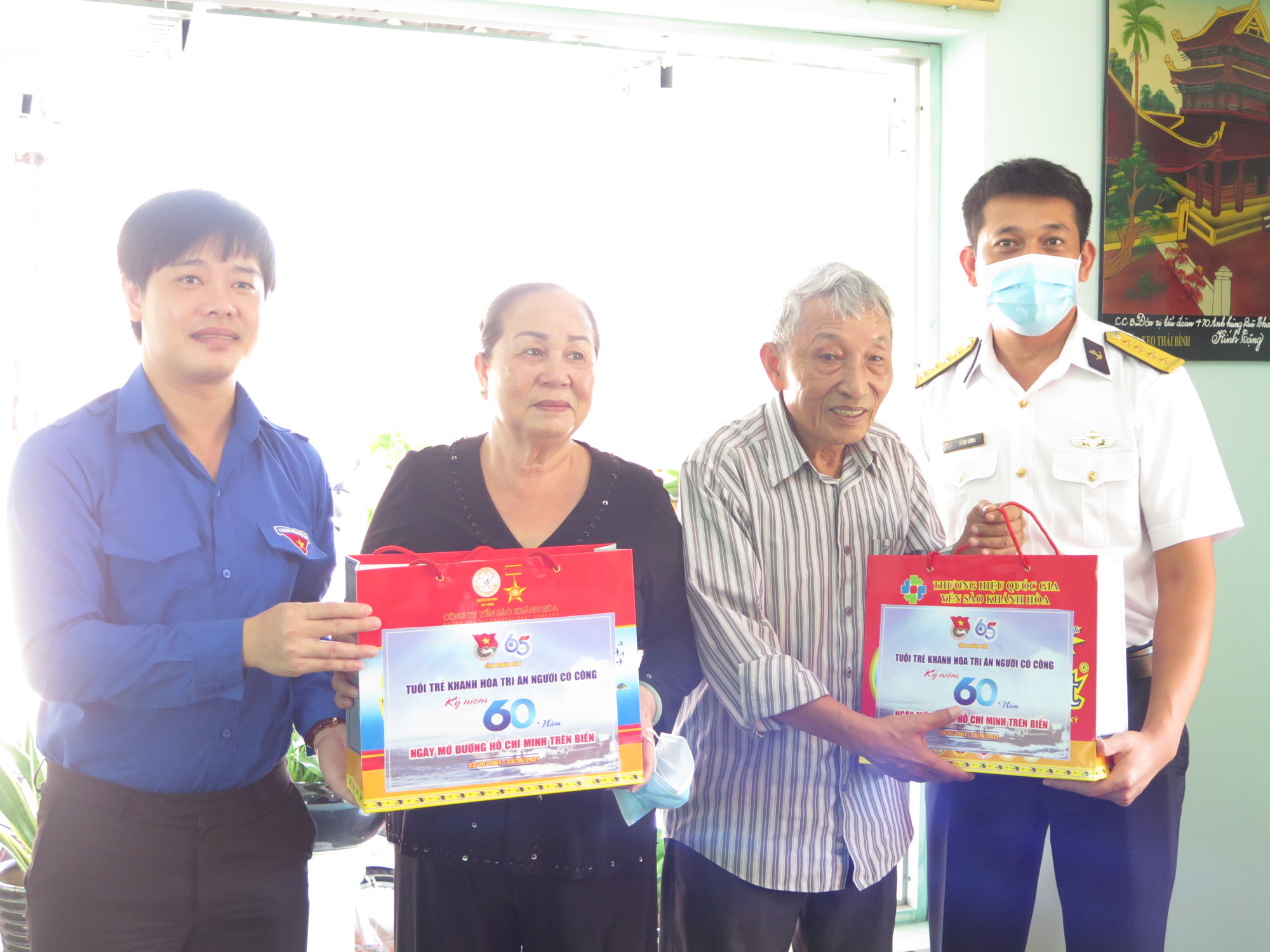 Anh Bùi Hoài Nam, Bí thư Tỉnh đoàn Khánh Hòa (bìa trái) cùng đại diện Vùng 4 Hải quân trao quà tri ân cho bà Phạm Thị Hường và ông Nguyễn Bá Cường, người có công hỗ trợ tàu C235