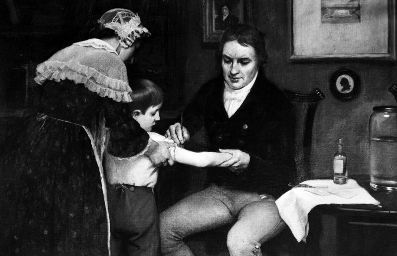Bác sĩ Anh Edward Jenner (1749-1823) thực hiện tiêm vắc xin lần đầu tiên cho James Phipps, một cậu bé 8 tuổi, vào ngày 14/5/1796 - Tranh của E. Board tại Bảo tàng Welcome, London