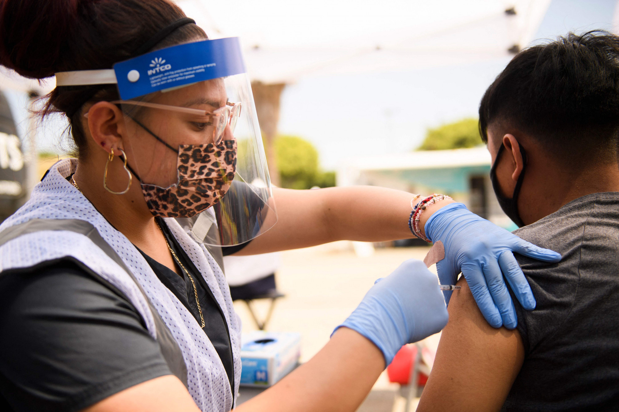 Một thanh niên 17 tuổi được tiêm một liều vắc-xin Pfizer Covid-19 tại một phòng tiêm chủng lưu động ở Los Angeles vào ngày 7 tháng 8 năm 2021. ẢNH: AFP