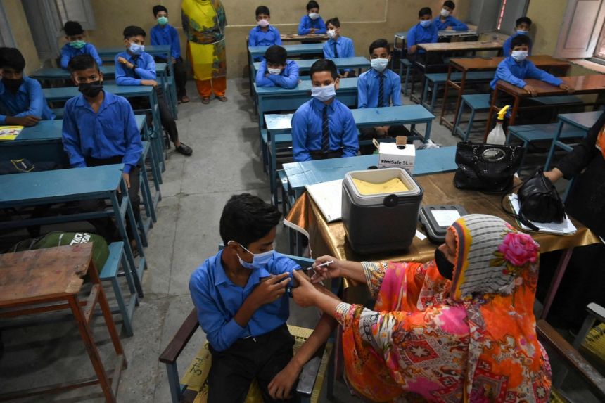 Một học sinh được tiêm một liều vắc-xin Pfizer Covid-19 ở Lahore, Pakistan, vào ngày 30 tháng 9 năm 2021. ẢNH: AFP