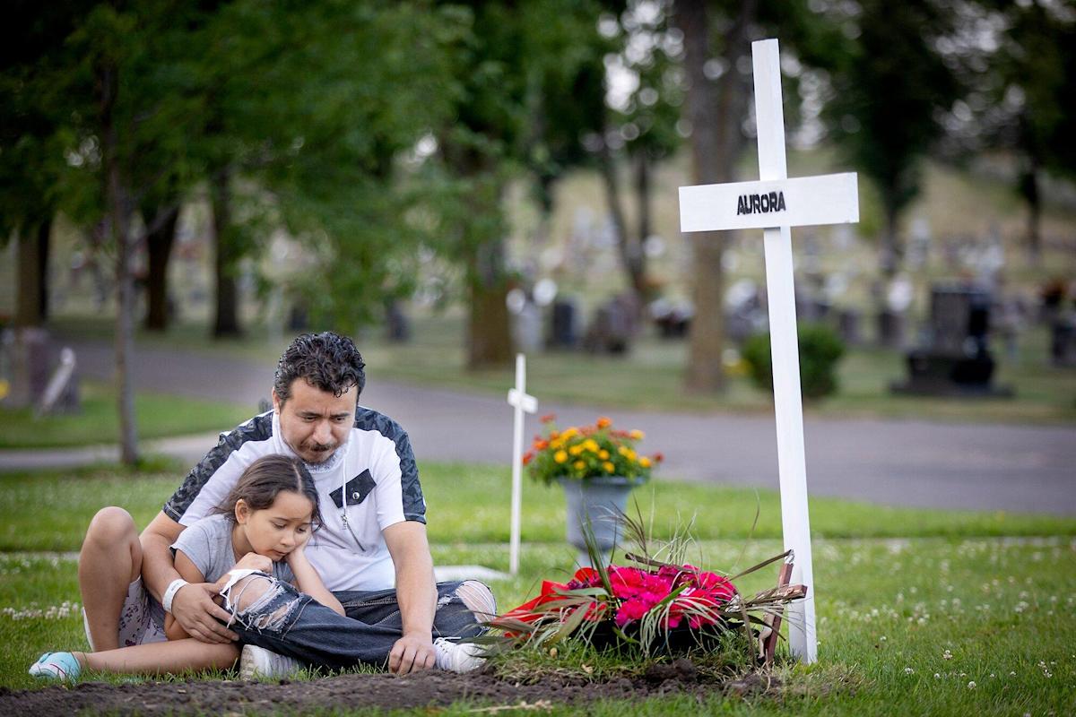 Juan Duran-Gutierrez với con gái Aurora đau buồn trước bia mộ của người vợ đã mất vì COVID-19.
