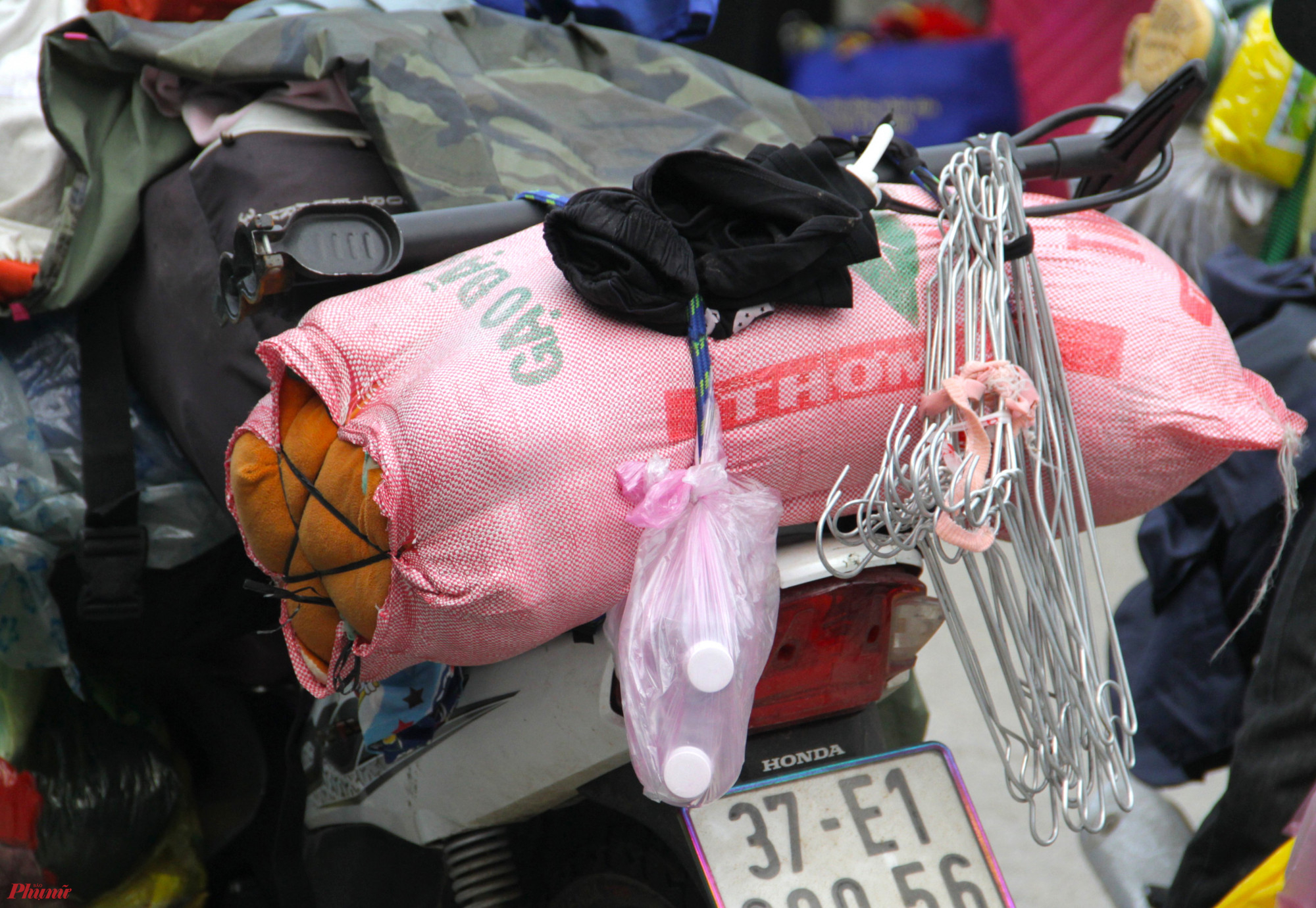Không chỉ quần áo, nhiều vật dụng như chăn, chiếu, móc treo quần áo… cũng được “nhét” lên xe máy để hồi hương.