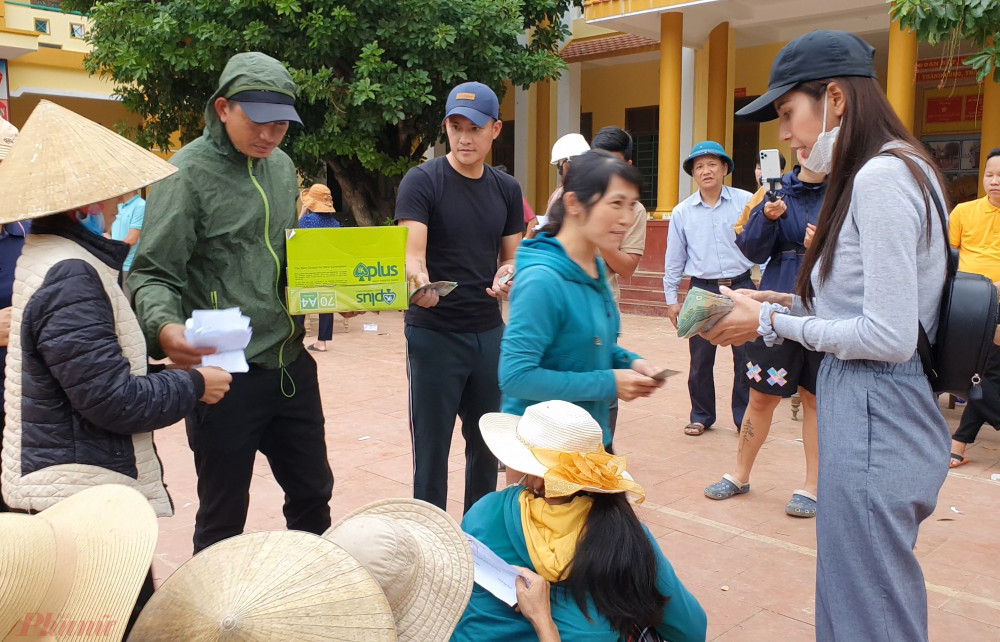 Công Vinh và Thủy Tiên trao tiền hỗ trợ cho người dân tại xã Lộc Thủy. Ảnh: Trường Nguyên