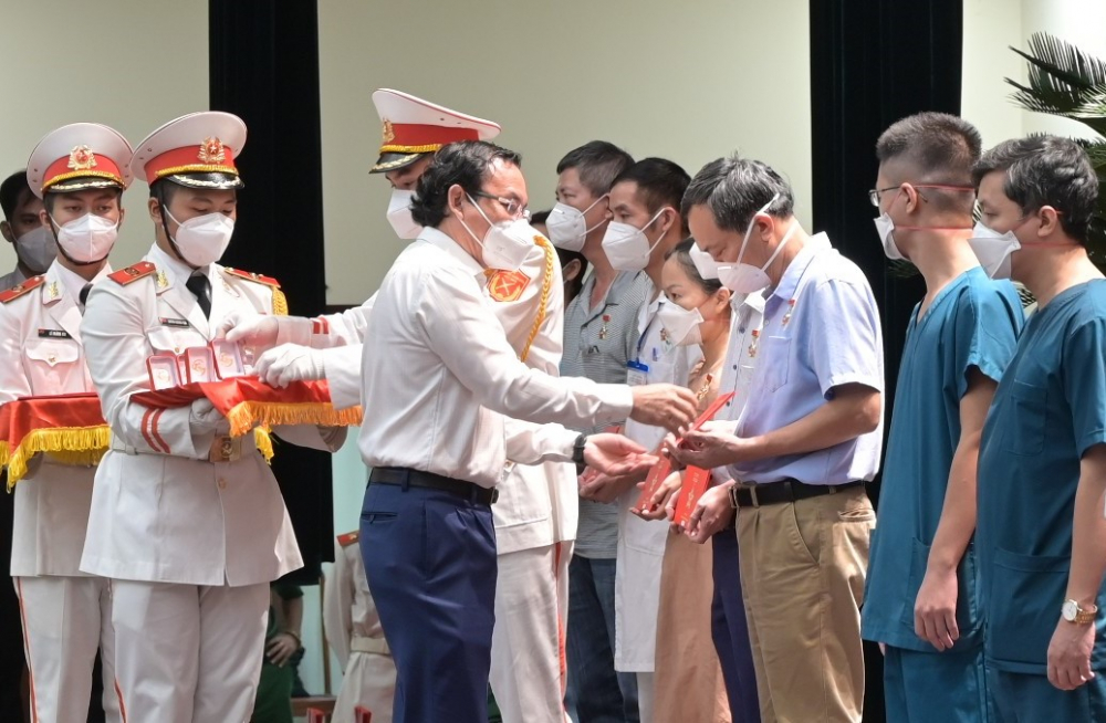 Bí thư Thành ủy TPHCM Nguyễn Văn Nên trao Huy hiệu TPHCM cho các cá nhân tình nguyện - Ảnh: Quốc Thanh