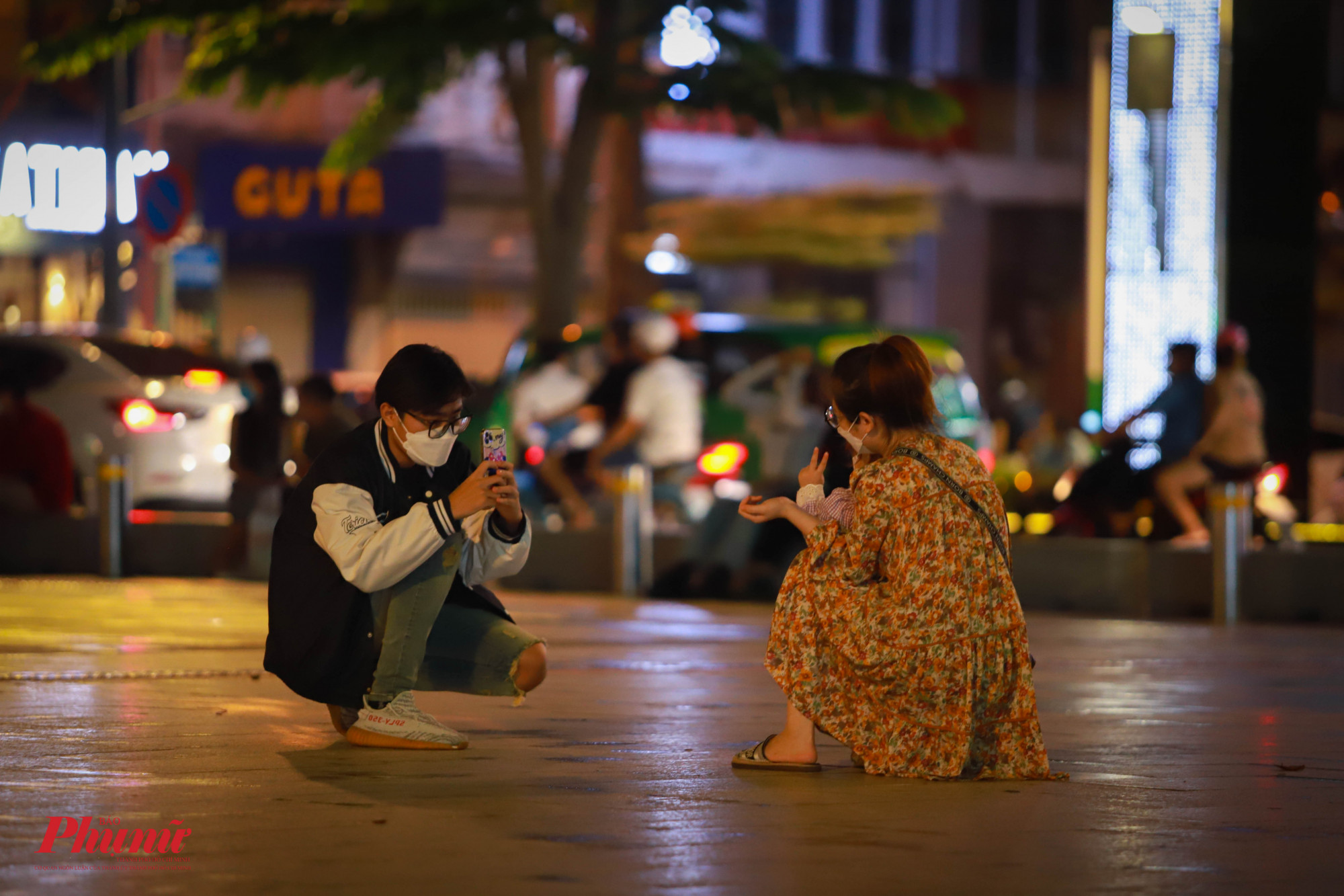 Một gia đình nhỏ chụp ảnh cho nhau tại phố đi bộ Nguyễn Huệ