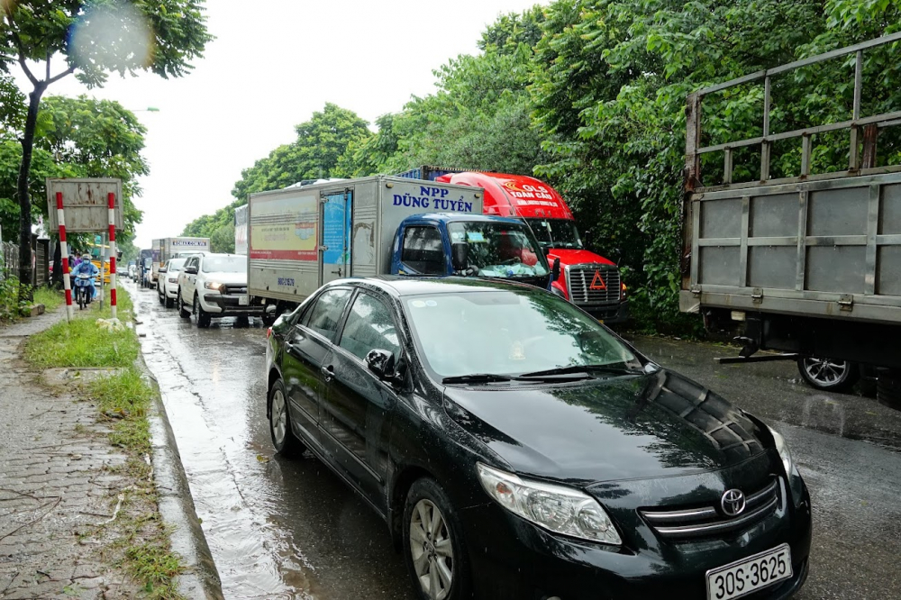 Sau trận mưa lớn sáng 11/10, đường gom đại lộ Thăng Long ngập sâu khiến hàng dài ôtô, xe máy ùn tắc gần 2 km.