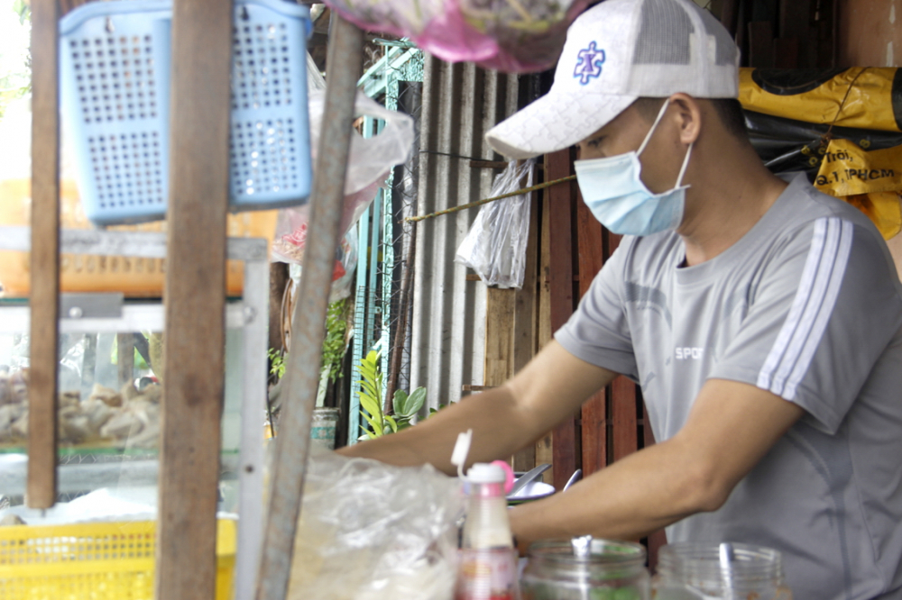 Anh Võ Minh thường xuyên đeo khẩu trang và dùng cồn khử khuẩn khi thối tiền cho khách