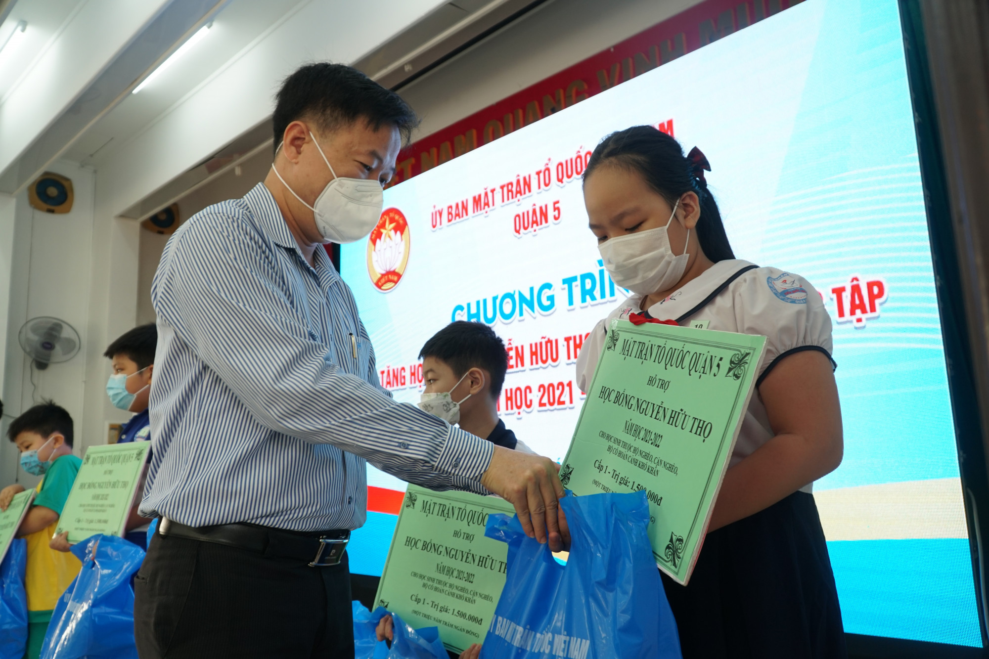 Ông Lê Tấn Tài - Chủ tịch Ủy ban MTTQ Việt Nam quận 5 trao biểu trưng học bổng Nguyễn Hữu Thọ cho học sinh có hoàn cảnh khó khăn những phấn đấu học tập tốt